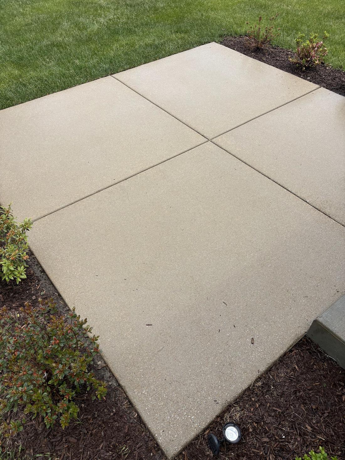 Concrete patio restored to clean tan after pressure washing