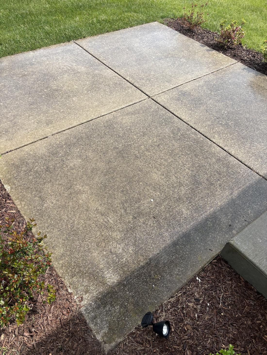 Concrete patio stained gray before pressure washing