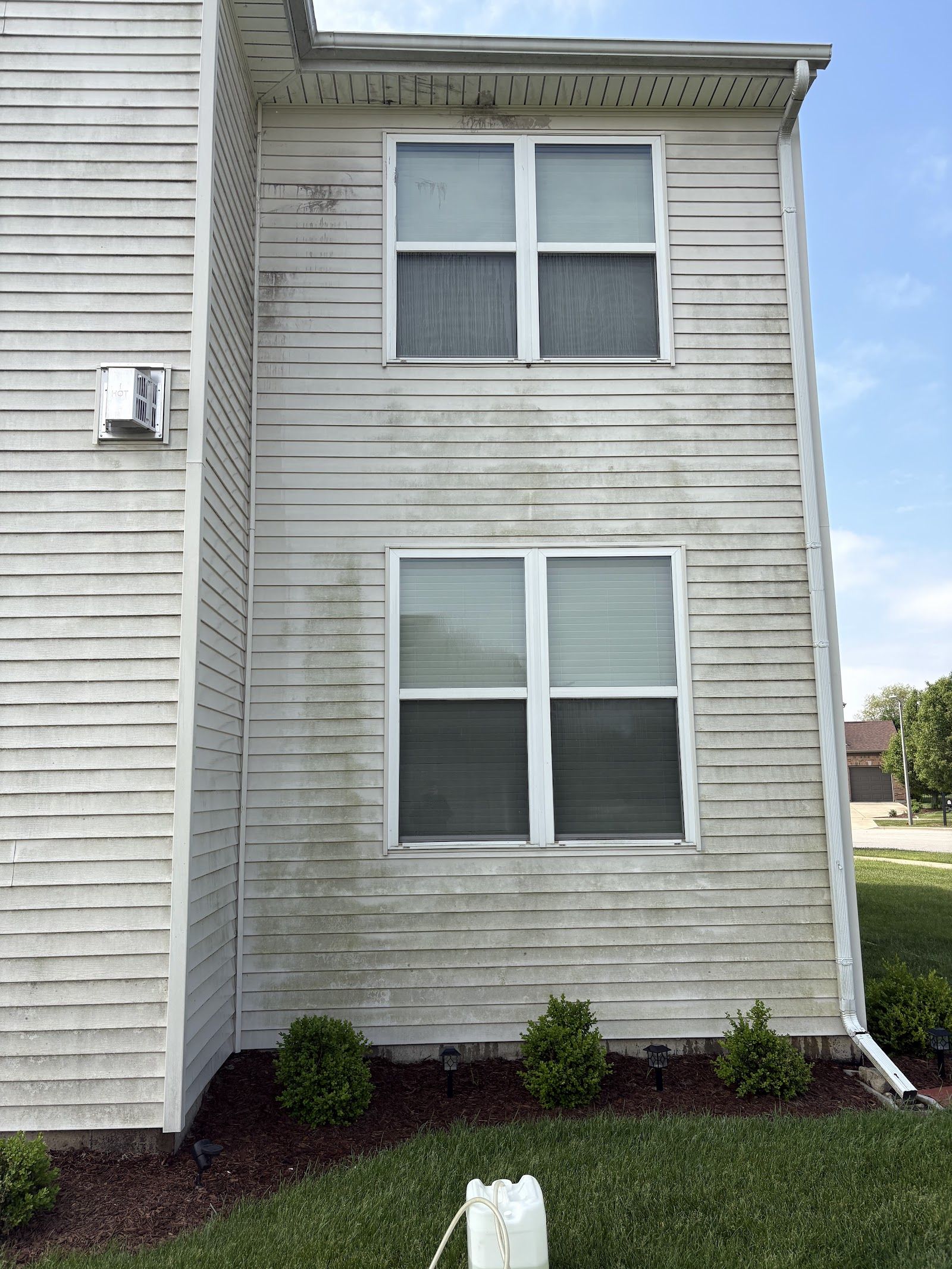 Home siding before exterior cleaning, dull and streaked